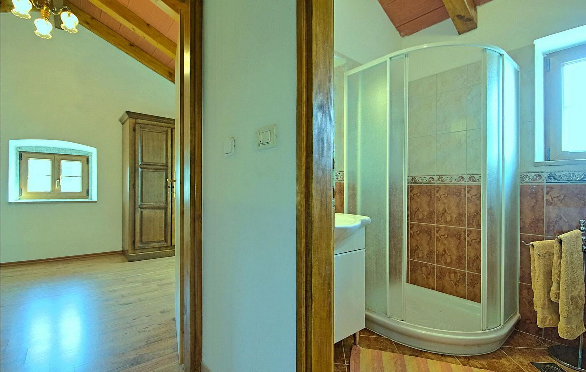 A bathroom with a shower, a toilet, and a sink.