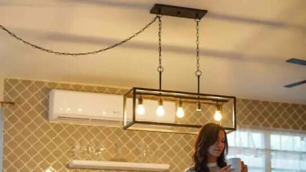 A modern kitchen with a hanging light fixture, a countertop with a fruit bowl, and a person standing by the counter. - Surfer Villa +Pool in Rincon’s Heart walk to Beach (Rincon)