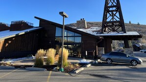A modern building with a large wooden structure, a metal tower, and a car parked in front. - Comfortable Condo in Park City (Park City)