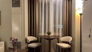 A small room with a table and two chairs, a potted plant, and a window with sheer curtains. - Comfortable Condo in Park City (Park City)