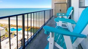Un balcon avec vue sur la plage et une piscine.