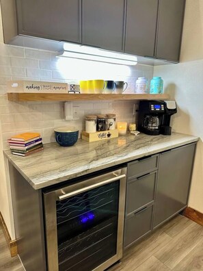 A kitchen with a built-in oven, a coffee maker, and various kitchenware on the countertop. - All is Found Riverfront Cabin with Sauna (Broken Bow)