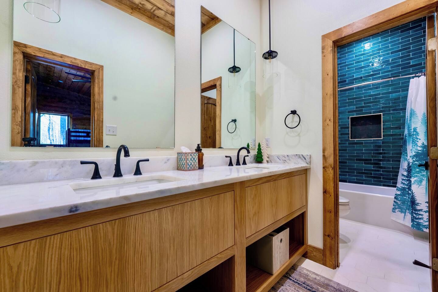 Un baño moderno con tocador de madera, lavamanos dobles y un espejo grande.