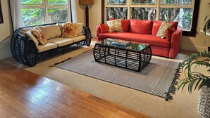 Una sala de estar con un sofá, un sofá rojo, una mesa de centro y una lámpara de pie.