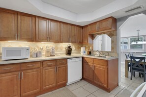 A modern kitchen with wooden cabinets, a microwave, and a dishwasher.