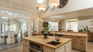 Una cocina amplia con una isla grande, electrodomésticos modernos y mucha luz natural.