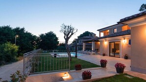 Eine moderne Villa mit Pool, Sitzgelegenheit im Freien und einem gepflegten Garten.
