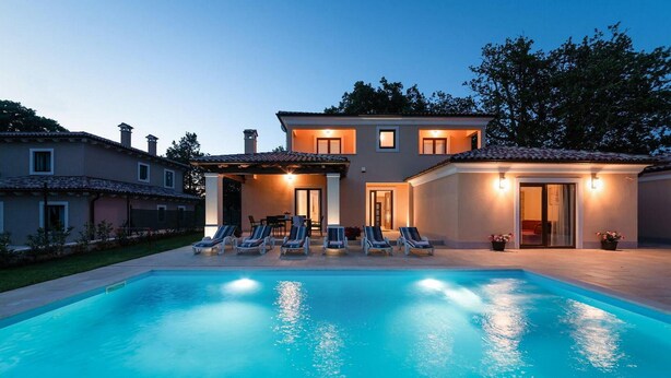 Ein modernes Haus mit Schwimmbad, mehreren Liegestühlen und einer überdachten Terrasse.