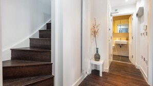 A staircase leading to a bathroom with a white sink and a mirror. - Farringdon/St Pancras penthouse (London)