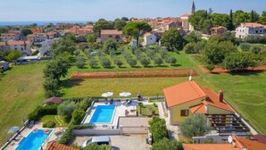 A residential area with a swimming pool, a church, and a view of the sea. - Stunning home in Kastelir-Labinci (Kastelir-Labinci)