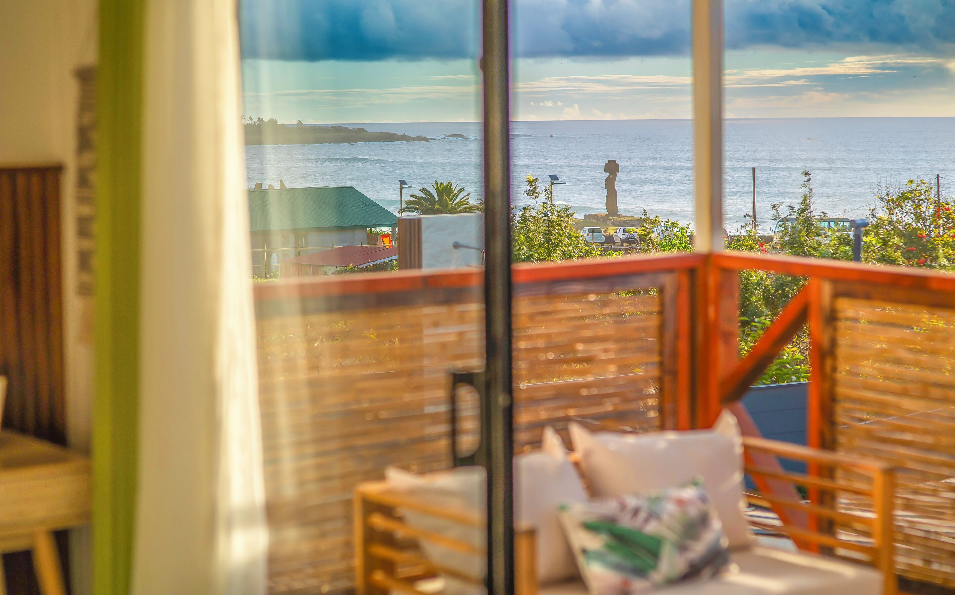 Un balcon avec vue sur la mer, une statue et quelques plantes.