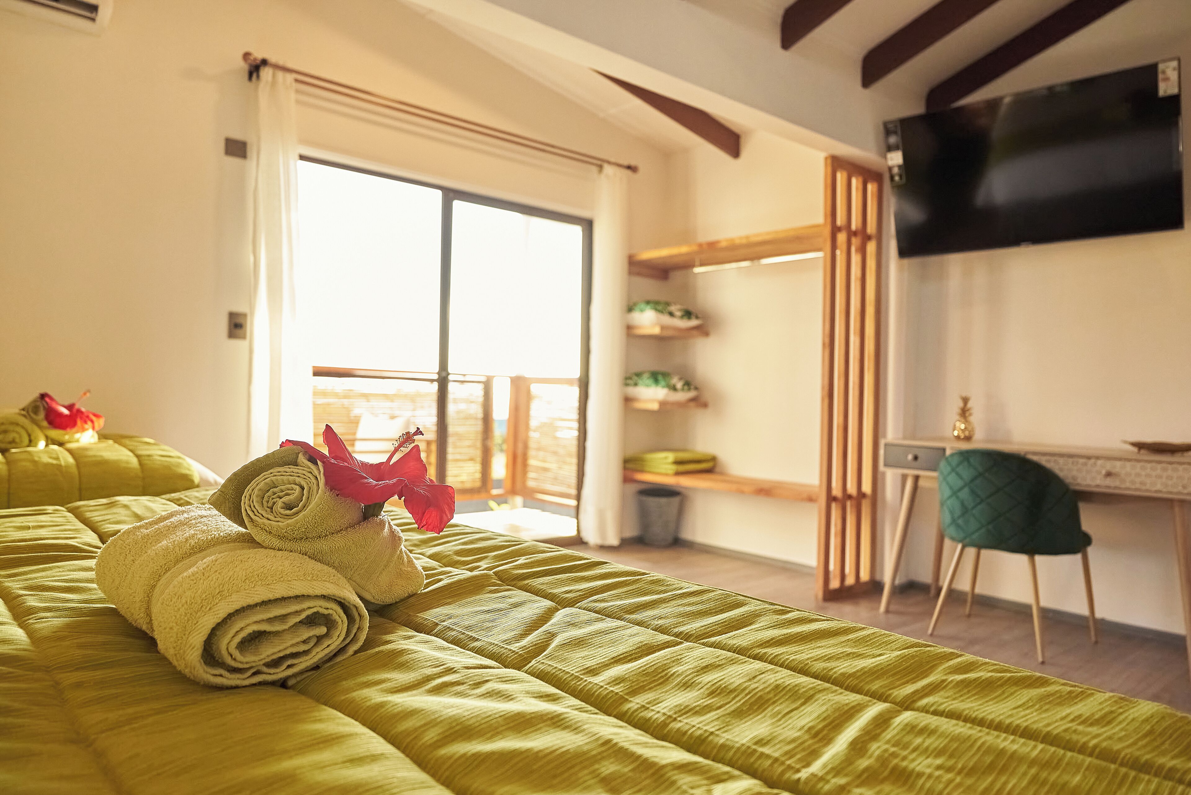 Una habitación de hotel con una cama grande, un escritorio, una silla y un televisor instalado en la pared.