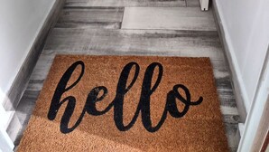 Una escalera de madera con un felpudo marrón que dice 'hello' al final.