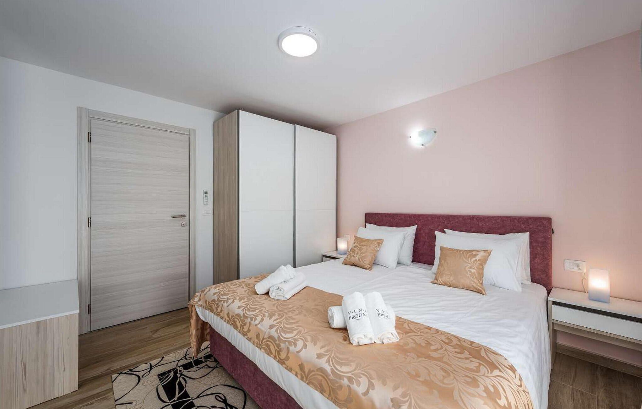 A hotel room with a bed, bedside tables, a wardrobe, and a ceiling light.