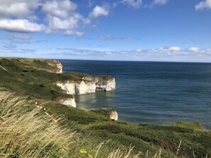 A coastal landscape with cliffs and a clear sky. - 2 4 bedroom cottages sleeping 16 in 8 bedrooms - pool and beach access included (Filey)