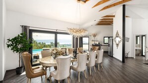 A dining area with a round table, multiple chairs, a chandelier, and a view of the outdoors. - Amazing home in Martina with sauna (Martina)