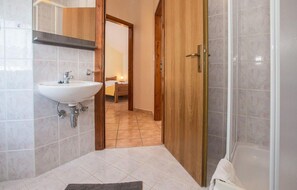 Enjoy a refreshing shower in the bathroom, featuring a sink and glass-enclosed shower.