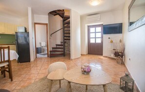 Cozy living space with a kitchen area, staircase, and comfortable seating area.
