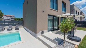 A modern two-story house with a swimming pool, outdoor seating, and a small tree. - Awesome home in Porec (Porec)
