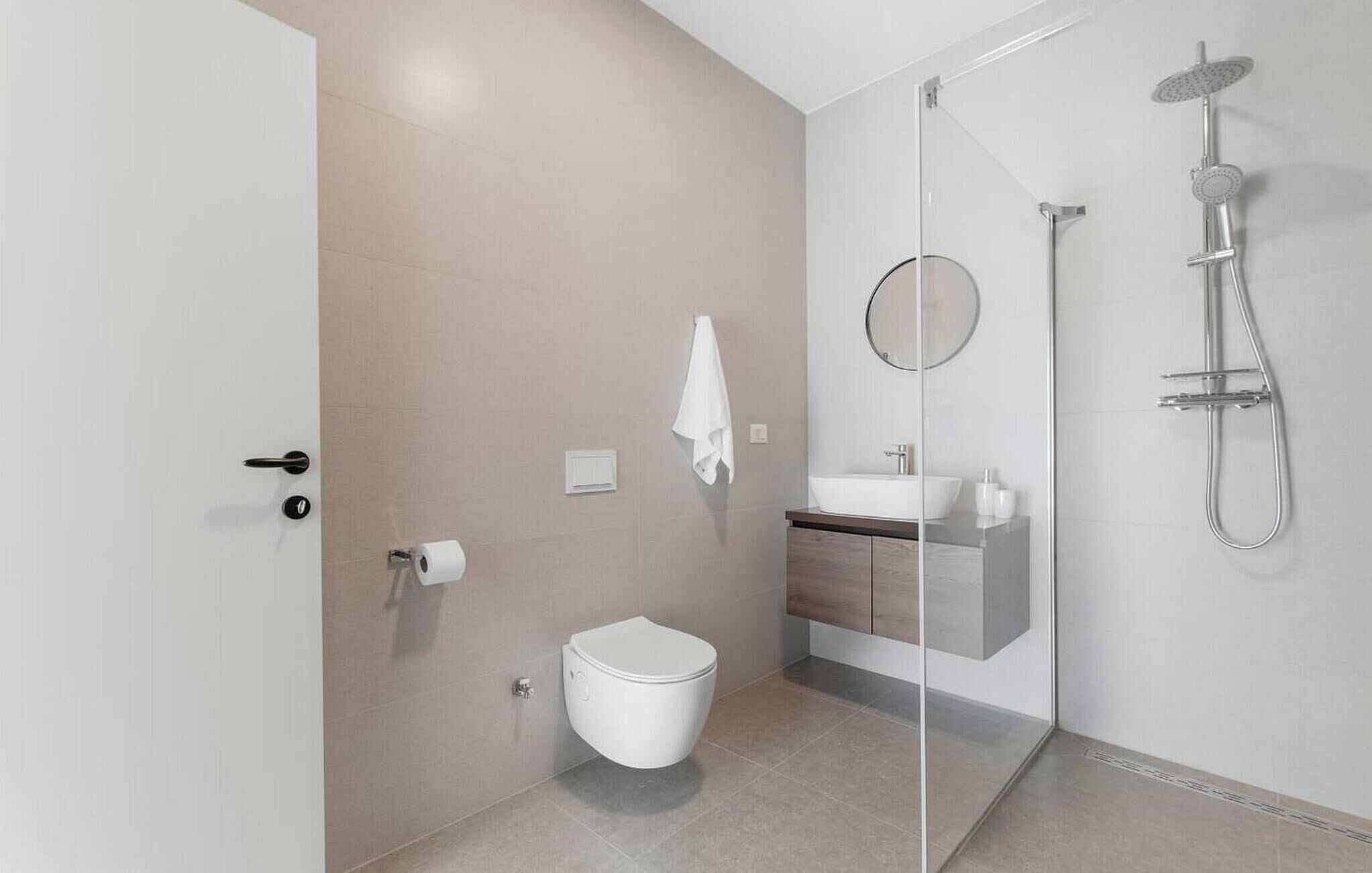 Un bagno moderno con toilette, lavandino e doccia.