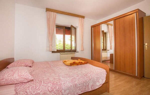 A bedroom with a bed, a wardrobe, and a window with curtains. - Awesome home in Porec with WiFi (Porec)