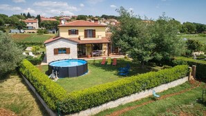 A two-story house with a swimming pool, a covered patio, and a well-maintained garden. - Beautiful home in Porec (Porec)