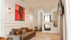 Ein modernes Wohnzimmer mit einer Couch, einem Kamin und einem Fernseher.