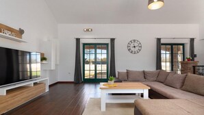 A modern living room with a large flat-screen TV, a wooden coffee table, a beige sofa, and a stone fireplace. - Beautiful home in Vodnjan (Vodnjan)