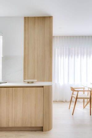 Modern kitchen with a central island and dining area, offering a clean and functional space.