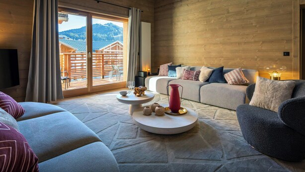 A modern living room with a sofa set, a coffee table, and a fireplace.