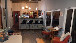 A modern living room with a sofa, chairs, a coffee table, and a dining area with a bar.