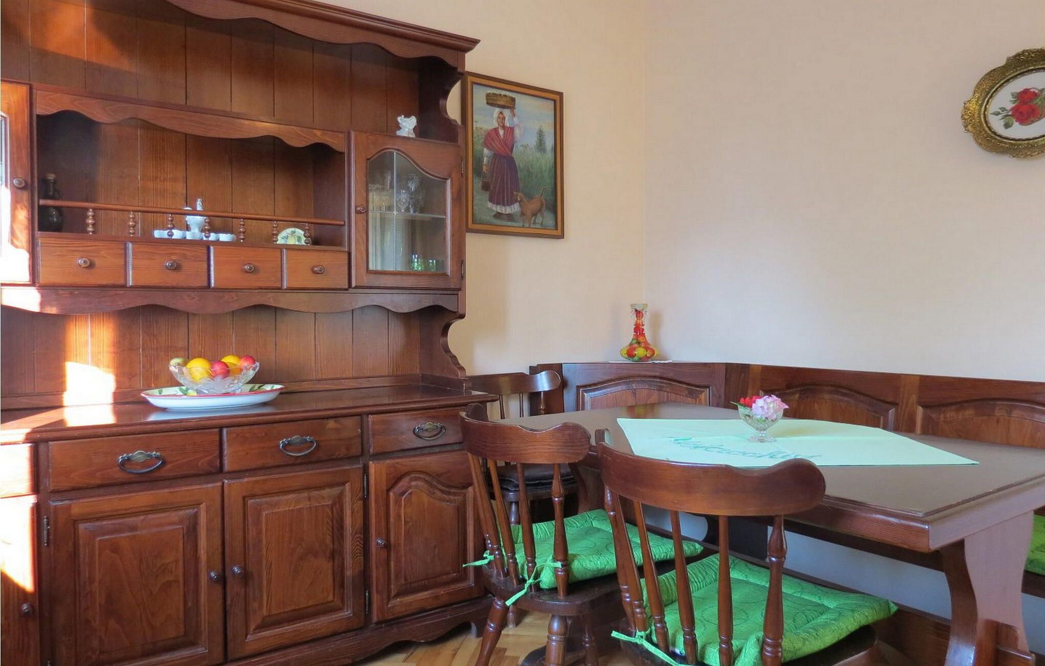 A traditional wooden dining room with a table, chairs, and a cabinet.