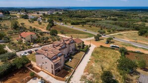 Un quartier résidentiel composé d’une rangée de maisons mitoyennes, d’une rue principale et offrant une vue sur la mer au loin.