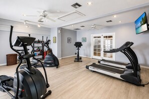 Un gimnasio en casa con cintas de correr, elípticas y una bicicleta estática.