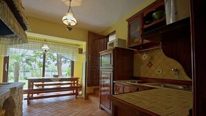 A kitchen with wooden cabinets, a built-in oven, and a window overlooking a garden. - 2 bedroom beautiful home in Labin (Labin)