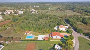 Vista aérea de una zona residencial con casas, piscina y una carretera.