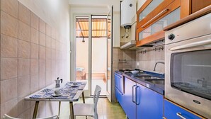 A compact kitchen with blue cabinets, a stove, and a sink.
