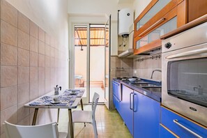 A compact kitchen with blue cabinets, a stove, and a sink.