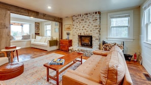 Una sala de estar acogedora con chimenea, un sofá, una mesa de centro y una pared de piedra.