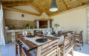 Enjoy a romantic dinner for two in this charming dining area with a stone fireplace and wooden beams.