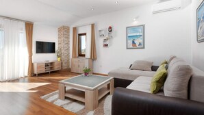 Ett modernt vardagsrum med en soffa, ett soffbord, en tv och en öppen spis.