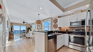 A spacious kitchen with white cabinets, stainless steel appliances, and a large island.