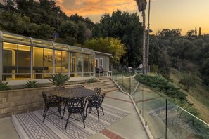 Enjoy a peaceful retreat with a glass-enclosed patio area and stunning views of the surrounding landscape.