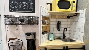 A compact kitchen with a coffee maker, a microwave, and a toaster.