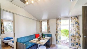 A compact living space with a kitchenette, a dining area, and a sofa.