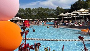 A swimming pool area with lounge chairs and umbrellas.