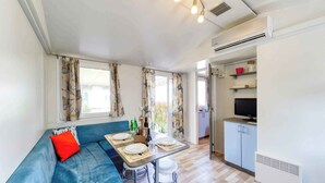A compact living space with a sofa, dining table, and kitchenette.