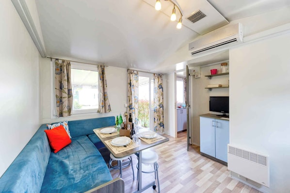 A compact living space with a sofa, dining table, and kitchenette.