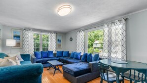 Een gezellige woonkamer met een modulaire bank, een ronde tafel en een lamp.