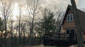 A cabin with a deck, surrounded by trees and a dirt path. - Secluded A frame cabin close Dells, BRAND NEW HOT TUB, firepit, grill. (Oxford)